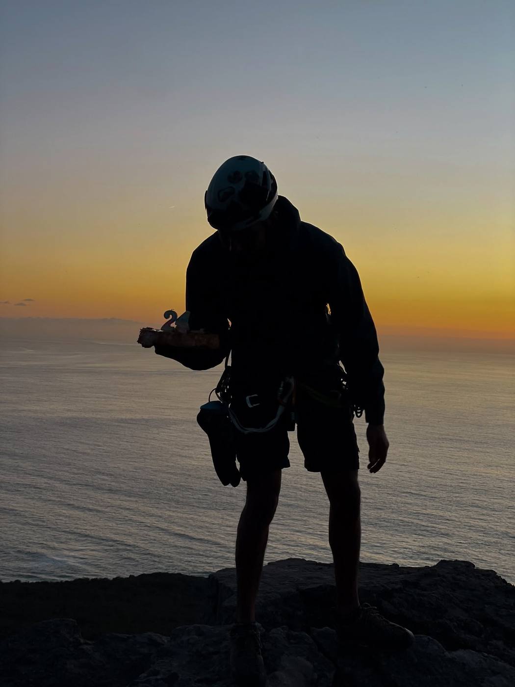 Silhouette of a climber at sunset overlooking the Mediterranean sea